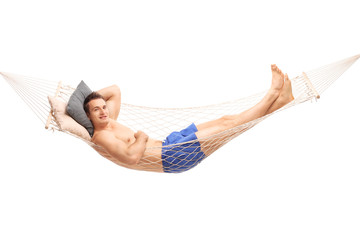 Carefree shirtless man lying on a hammock