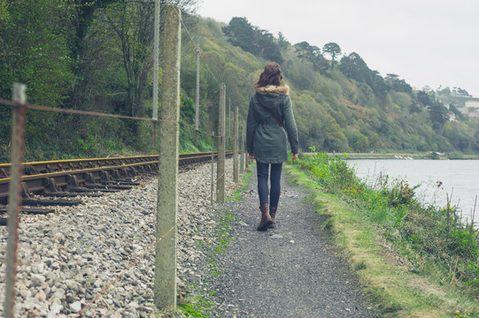 Young woman walking by railway tracks