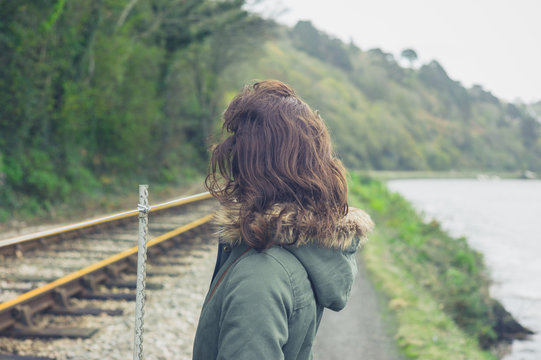 Young woman standing by railway tracks