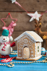 Homemade gingerbread house with candy windows on a blue wooden table