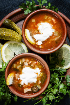 Home Russian meat hodgepodge (solyanka) with sour cream in a cla
