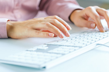 Woman office worker typing on the keyboard