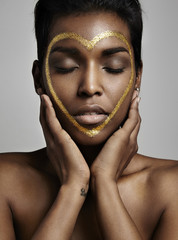 black woman with a golden heart on her face