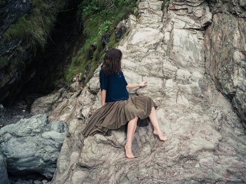 Beautiful young woman relaxing on rock