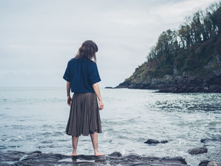 Young woman standing by the water on beach