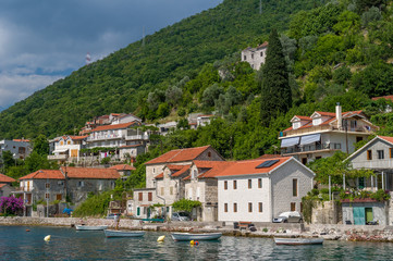 Fototapeta na wymiar Lepetane old town under the mountains.Eembankment view from water.