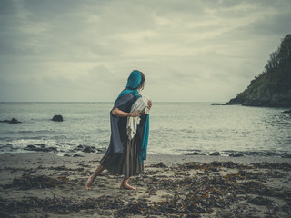Vintage shot of woman on beach with baby © LoloStock
