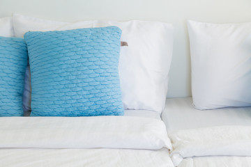 Fototapeta na wymiar light blue pillows white mattress bed, soft focus