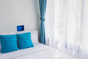 light blue theme pillows white mattress bedroom light through curtain