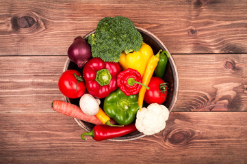 Fresh vegetables on the wooden tray on the rustic background.