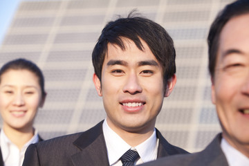 Three Businesspeople in front of Solar Panel