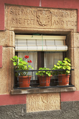 ventana antigua con inscripciones y flores y  en pueblo  de girona