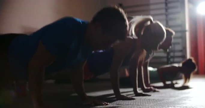 Four people doing press ups at a gym