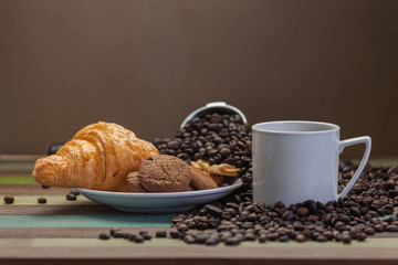 White coffee cup with cookies and beans
