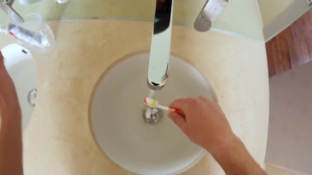 Point of view of man brushing teeth in a bathroom