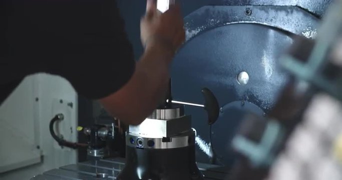 Male Engineer Operating CNC Machinery On Factory Floor