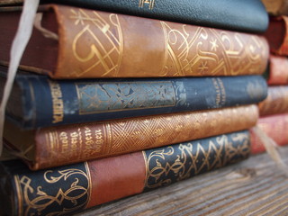 Pile of antique books on a wooden board.