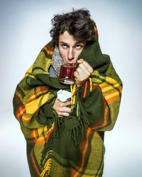Ill Man covered with plaid blanket with hot tea/ sick man suffering cold and winter flu virus. Medication or drugs abuse, healthcare concept