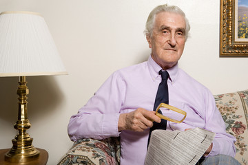 Man reading newspaper with magnifying glass