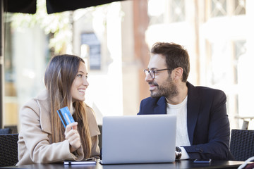 Online shopping. Happy couple using credit card to internet shop on-line. Young couple with Laptop Computer and Credit Card buying online.