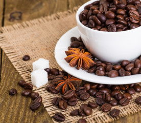 Cup and saucer filled with coffee beans and cane sugar