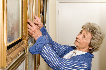 Woman adjusting picture frames