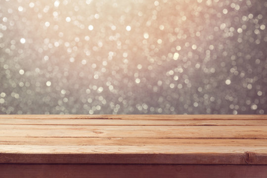 Festive background with empty wooden table over glitter bokeh lights