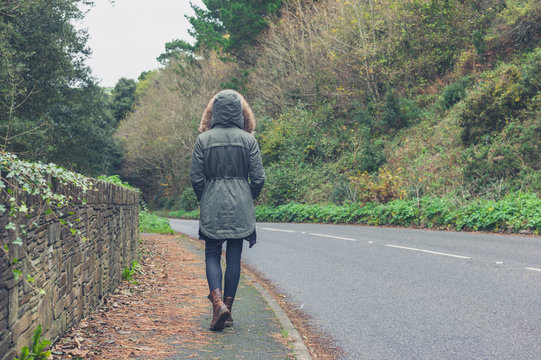Person in winter coat walking in countryside