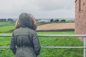 Person in winter coat by field