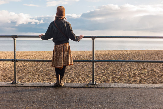Woman standing by railings on beach