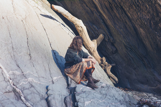 Young woman relaxing on rock in nature