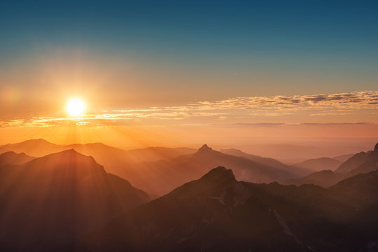 Fototapeta kolorowy zachód słońca na szczycie austriackich Alp górskich