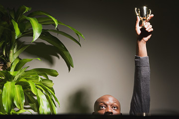 Businessman holding up his trophy