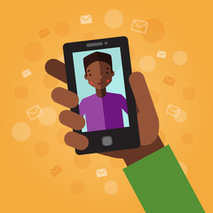 Smart phone in hand. On the orange background with envelopes and dots. Video call with young man (African American).