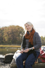 Senior woman sitting on rocks