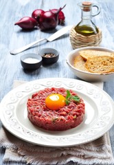 Steak tartar with egg yolk, red onion, capers, spicy sauce, sea salt, pepper and olive oil.