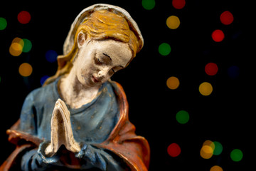 Detail of Blessed Mary Virgin with colorful stars at background. Nativity scene figures. Christmas traditions.