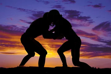 Foto op Canvas silhouette of football players hitting © Poulsons Photography