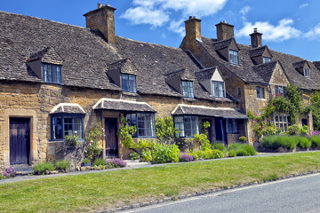 Fototapeta na wymiar Road in an English village with golden stone traditional cottages