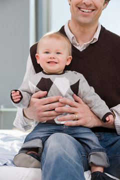 baby boy sat on his fathers knee
