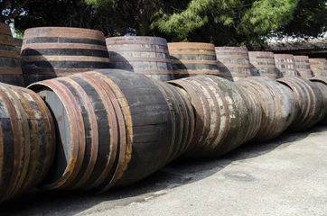 Fotobehang Barrels for whiskey or wine stacked in outdoor © KikoStock