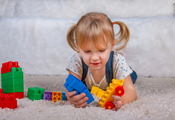 girl playing with plastic toys cubes constructions
