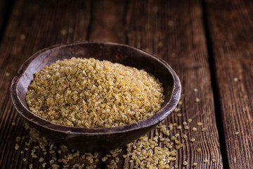 Raw Bulgur (on wooden background)