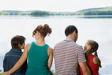 Family sitting by lake