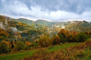 Fototapeta na wymiar Mountain landscape with clouds and colorful trees