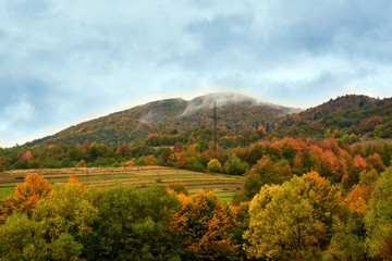 Obraz premium Mountain landscape with clouds and colorful trees
