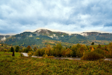 Naklejka premium Mountain landscape with clouds and colorful trees