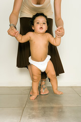 Mother helping baby to walk