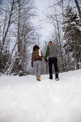 Rear view of a mature couple walking through snow