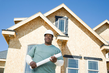 A builder holding a blueprint